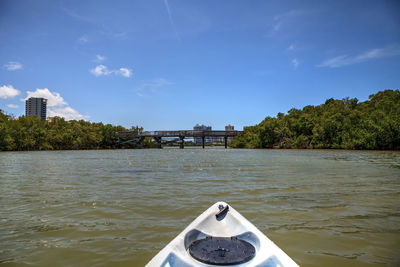 View of boat in river against cloudy sky