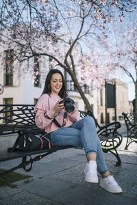 Full length portrait of woman sitting at park