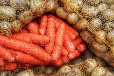 Stack of potatoes and carrots in sack