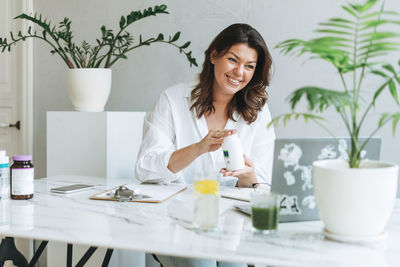 Young woman nutritionist in white shirt work at laptop. doctor communicates with the patient online