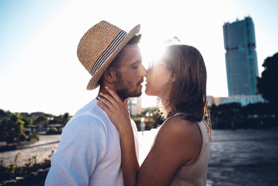 Portrait of couple kissing against sky