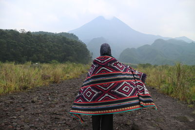 Rear view of woman with scarf standing on land