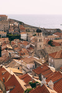 High angle view of townscape by sea against sky