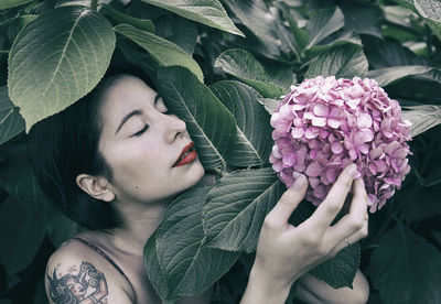 Close-up of woman smelling pink flowers