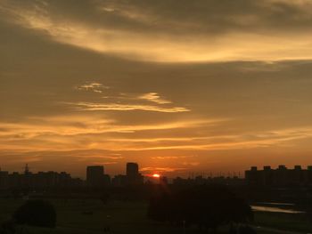 Silhouette buildings against sky during sunset