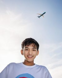 Portrait of boy standing against clear sky