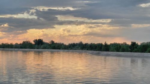 Scenic view of lake against sky at sunset