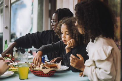 Girl having tacos with family at table in restaurant