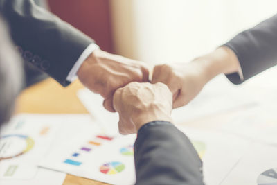 Midsection of man holding hands on table