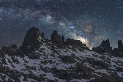 Scenic view of snowcapped mountains against sky at night