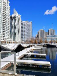 Modern buildings in city and marina against blue sky