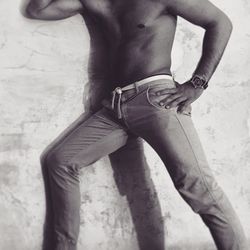 Close-up of shirtless man standing against wall