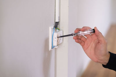 Close-up of man working against wall