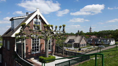Houses by building against sky