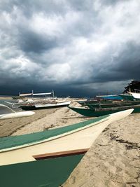 Boats moored on beach against sky