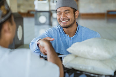 Smiling men shaking hands at mosque