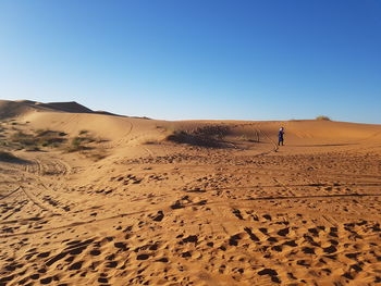 Scenic view of desert against clear blue sky