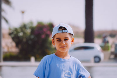 Portrait of boy standing against sky