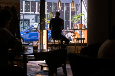 Rear view of man sitting at home