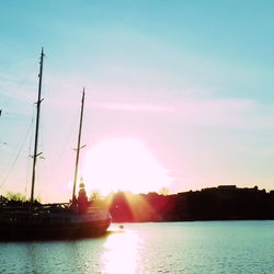 Sailboats sailing in sea against sky during sunset