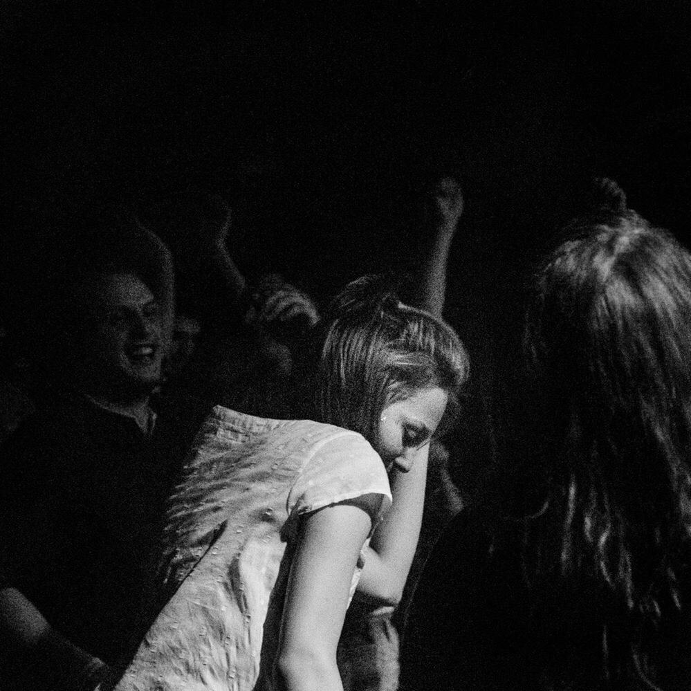 LOW ANGLE VIEW OF YOUNG WOMAN IN DARK