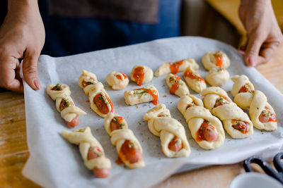 Midsection of woman holding food in baking sheet