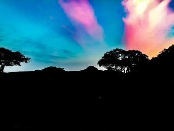 Low angle view of silhouette trees against sky