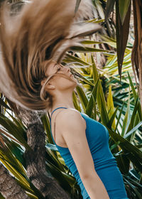 Young woman with palm leaves in plant