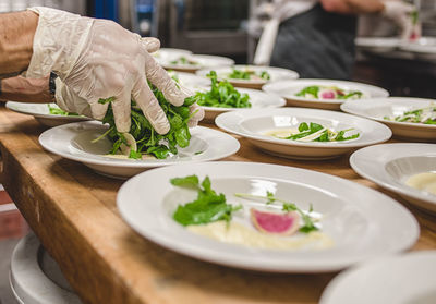 Cropped image of chef making salad in kitchen