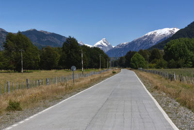 Road leading towards mountains against sky