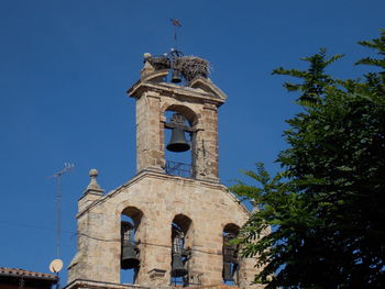 Low angle view of bell tower against blue sky