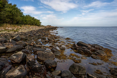 Rocks by sea against sky