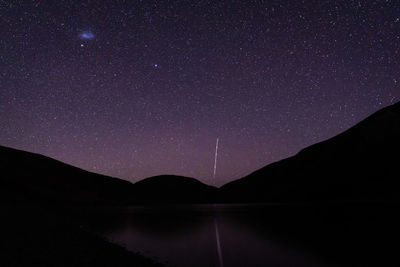 Scenic view of lake against sky at night