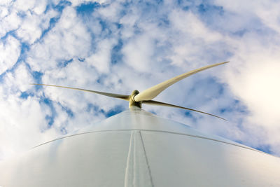 Low angle view of traditional windmill against cloudy sky