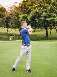 Full length of man playing golf course