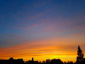 Low angle view of silhouette trees against romantic sky