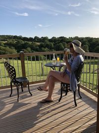 Side view of woman sitting on bench