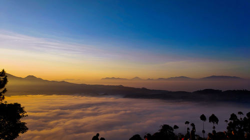 Scenic view of silhouette mountains against sky during sunset