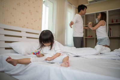 Girl watching video in mobile phone while parents arguing at home