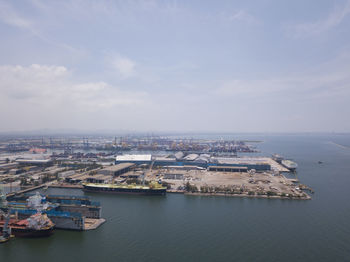 Aerial logistics commercial vehicles waiting to be load on to a car carrier ship at dockyard