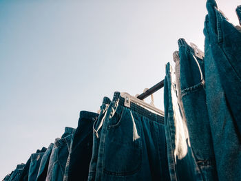 Low angle view of clothesline hanging against clear sky