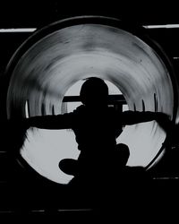 Rear view of silhouette man playing in tunnel