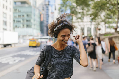 Portrait of smiling young woman standing on city street