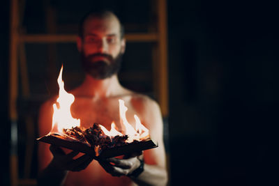 Young man holding burning candle