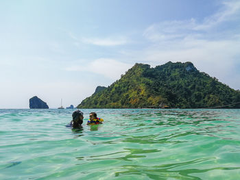 Father and daughter swimming in sea