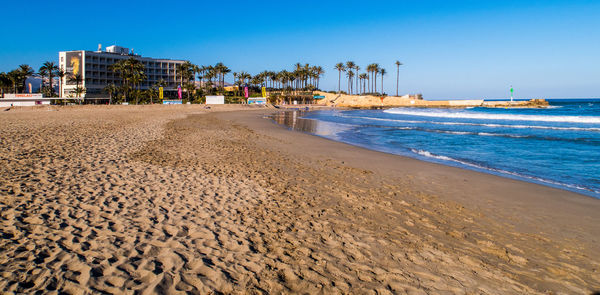 Scenic view of beach against clear blue sky