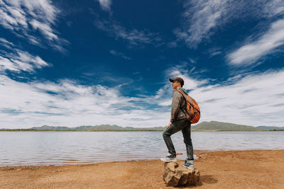 Full length of man standing on beach against sky