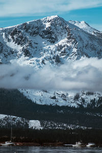 Scenic view of snowcapped mountains by lake against sky