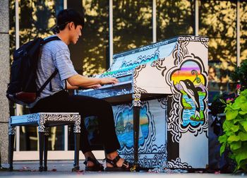 Full length of young woman sitting on wall