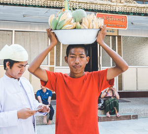 Portrait of man holding food while standing outdoors